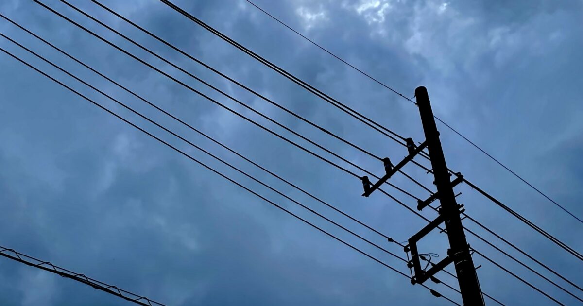 電線と曇り空が印象的な風景