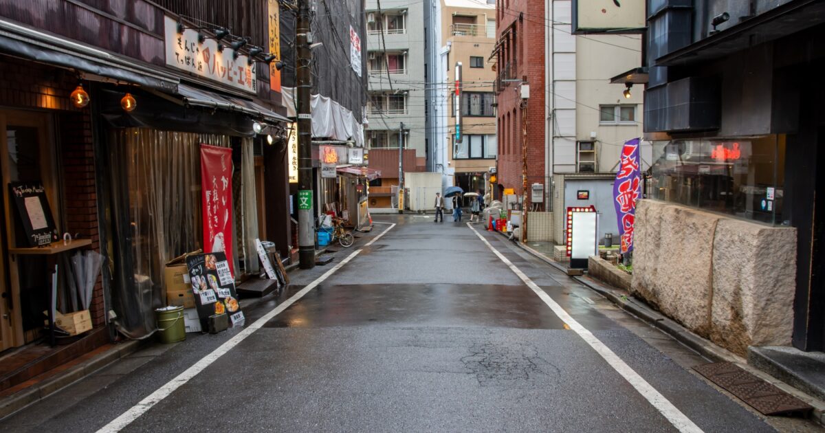 雨上がりの飲食店が並ぶ路地裏の街並み