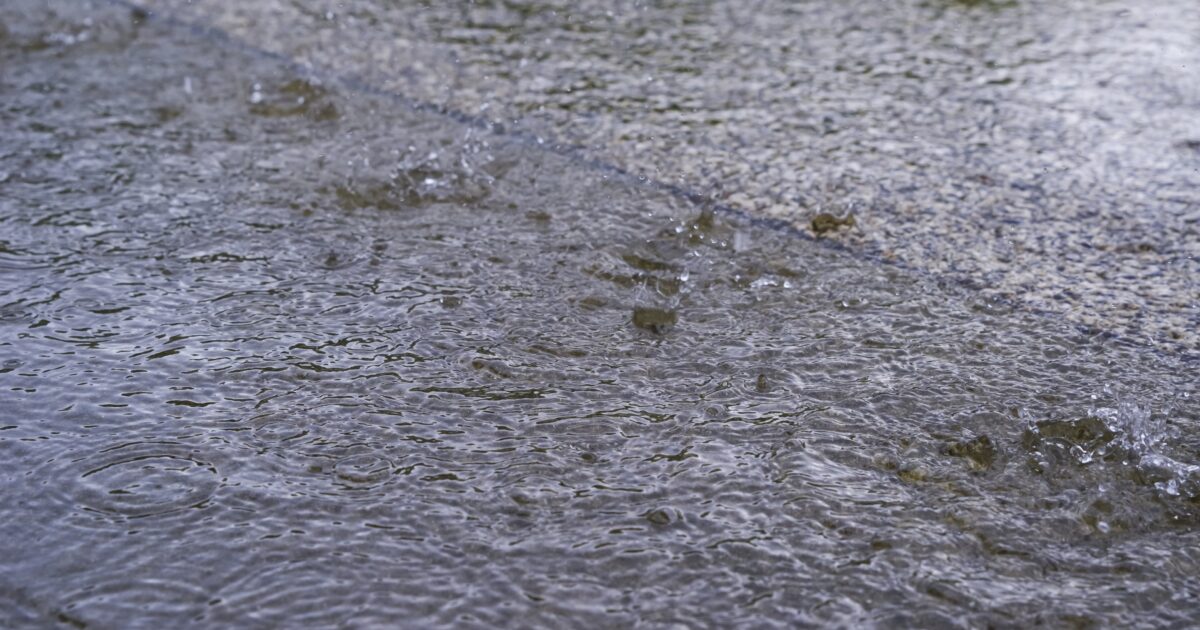 雨が降る舗装道路の水たまり