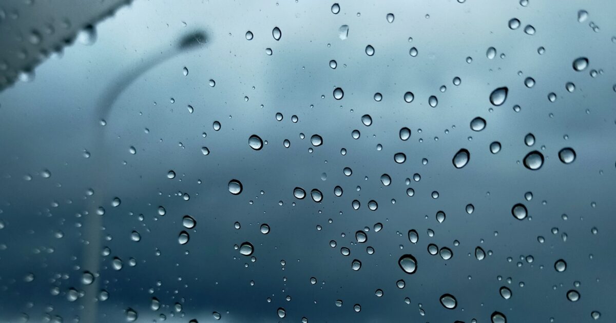 曇り空と車の窓ガラスに付いた雨粒