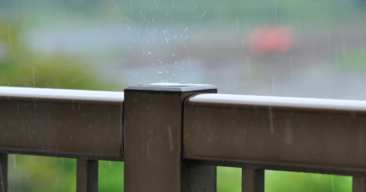 雨が当たる金属製の手すりと水しぶき