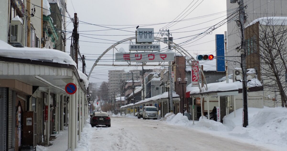 冬の北海道の商店街とミツウマのアーチ看板