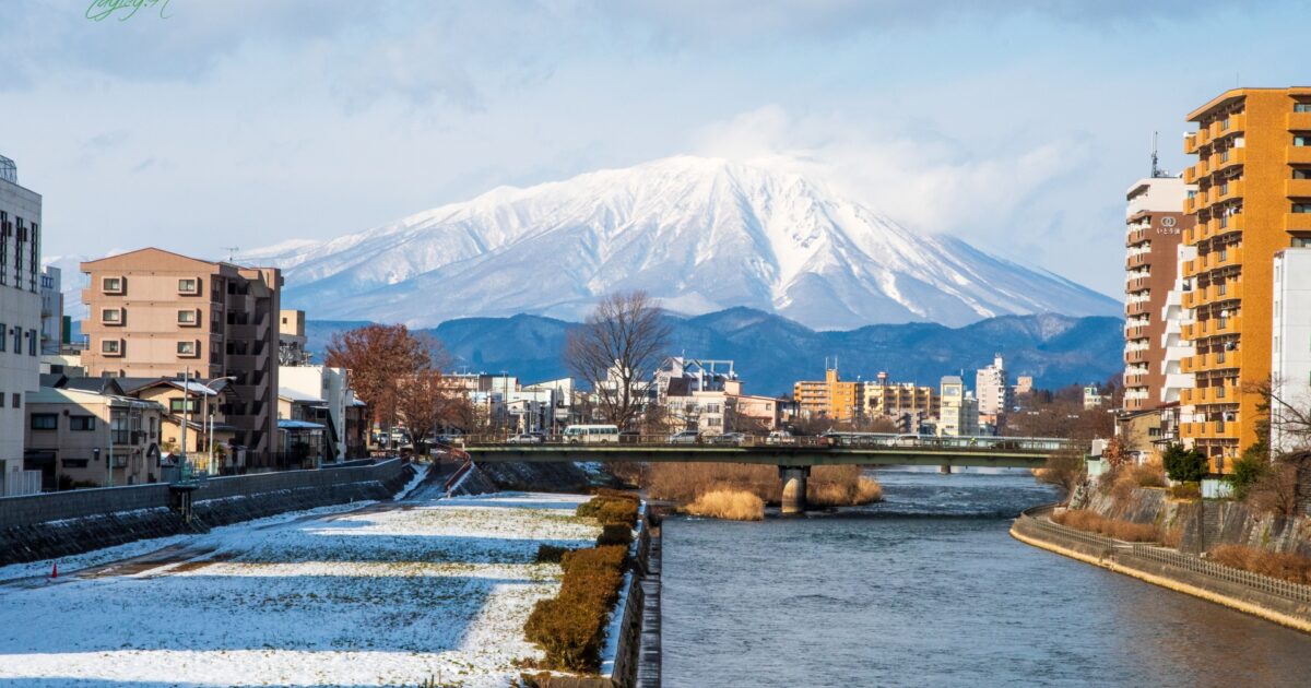 盛岡市内から望む雪化粧した岩手山と川の風景