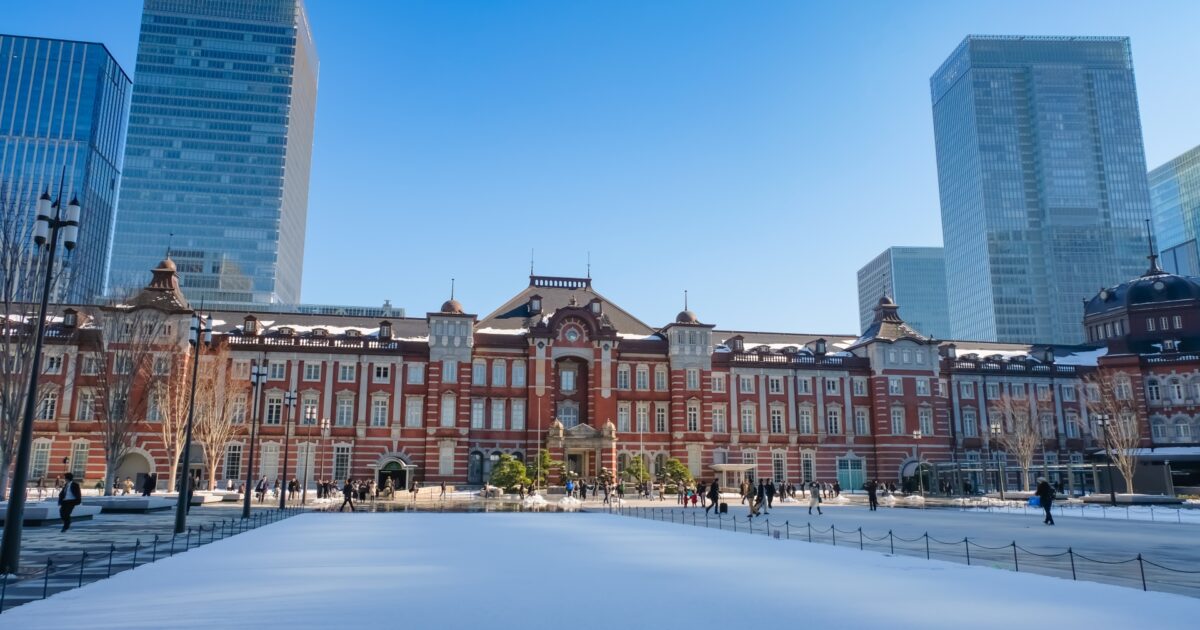雪化粧をした東京駅と周囲の高層ビル群
