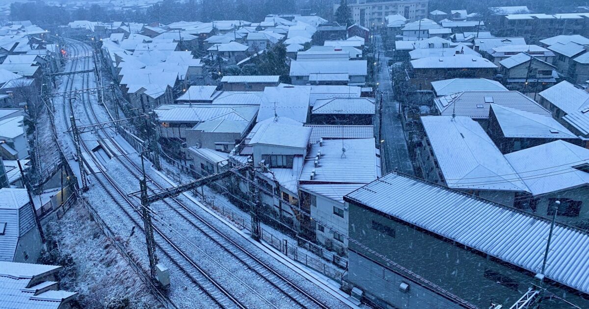 雪に覆われた住宅街と鉄道の俯瞰ビュー