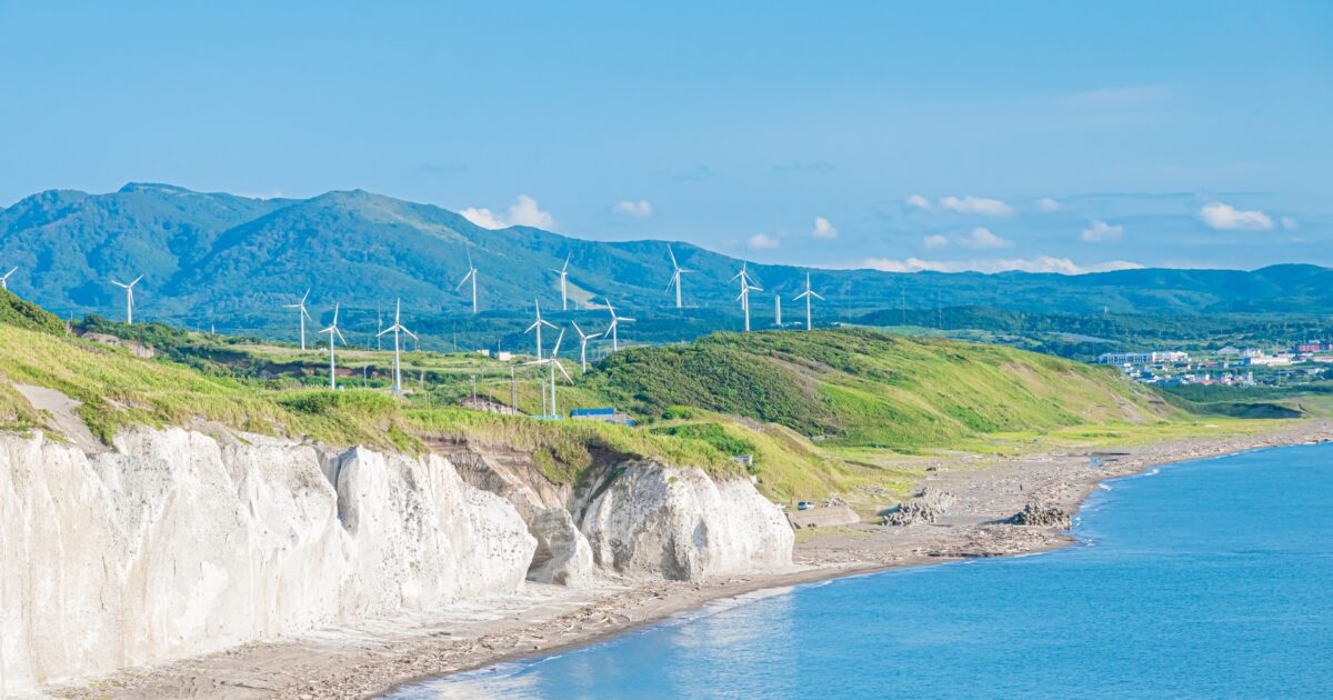 海岸線と風力発電の風車が並ぶ風景