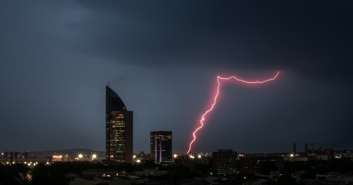 高層ビルに落ちる稲妻と雷雲の夜景