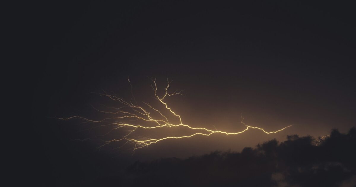 暗い夜空を横切る黄金色の稲妻