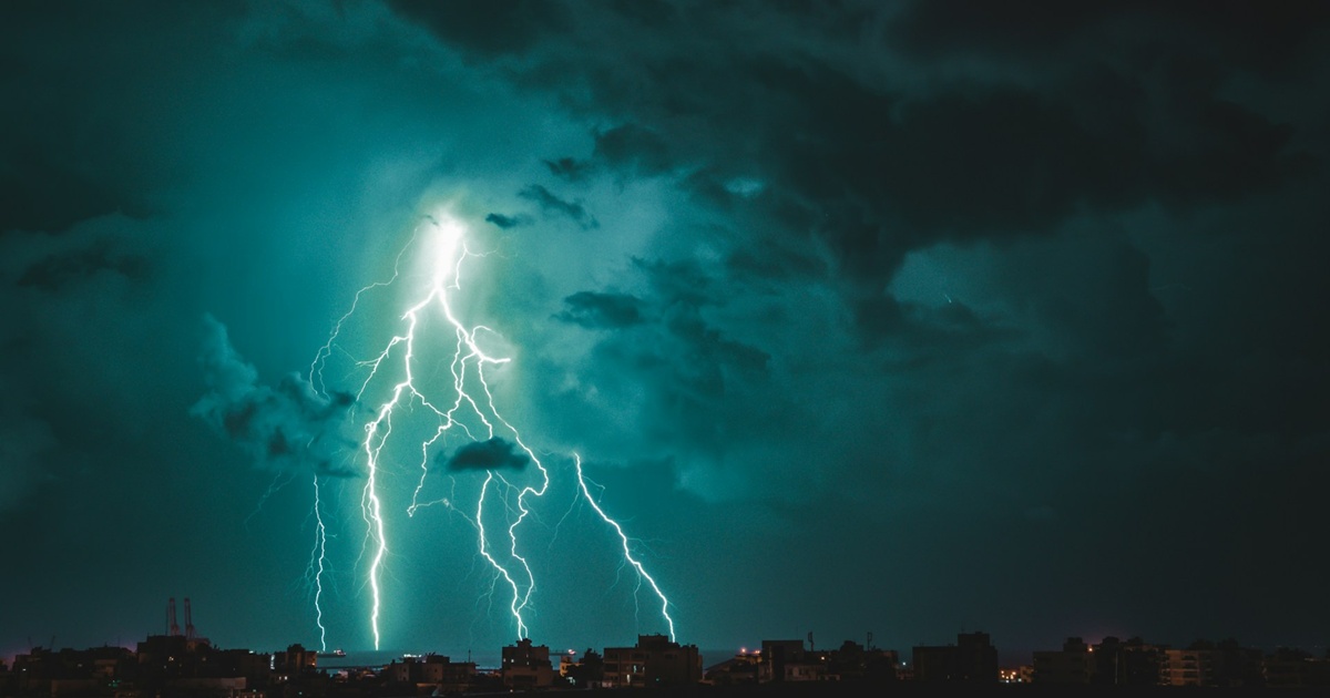 街並みに落ちる稲妻と緑色に輝く雷雲