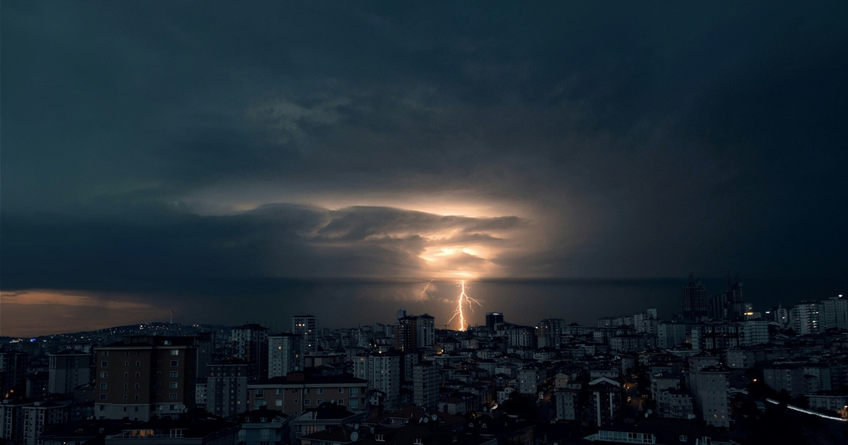 厚い雲と落雷に包まれた都市の夜景