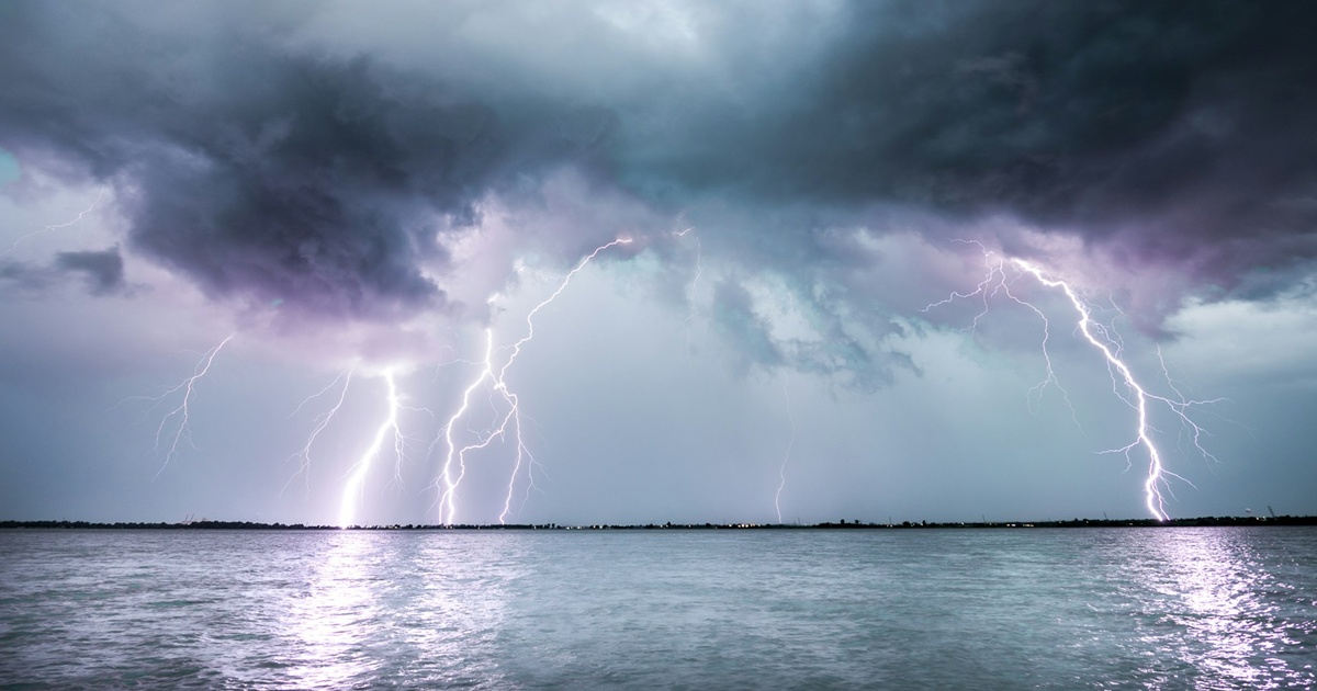 湖上に落ちる激しい雷と暗雲が迫る空模様