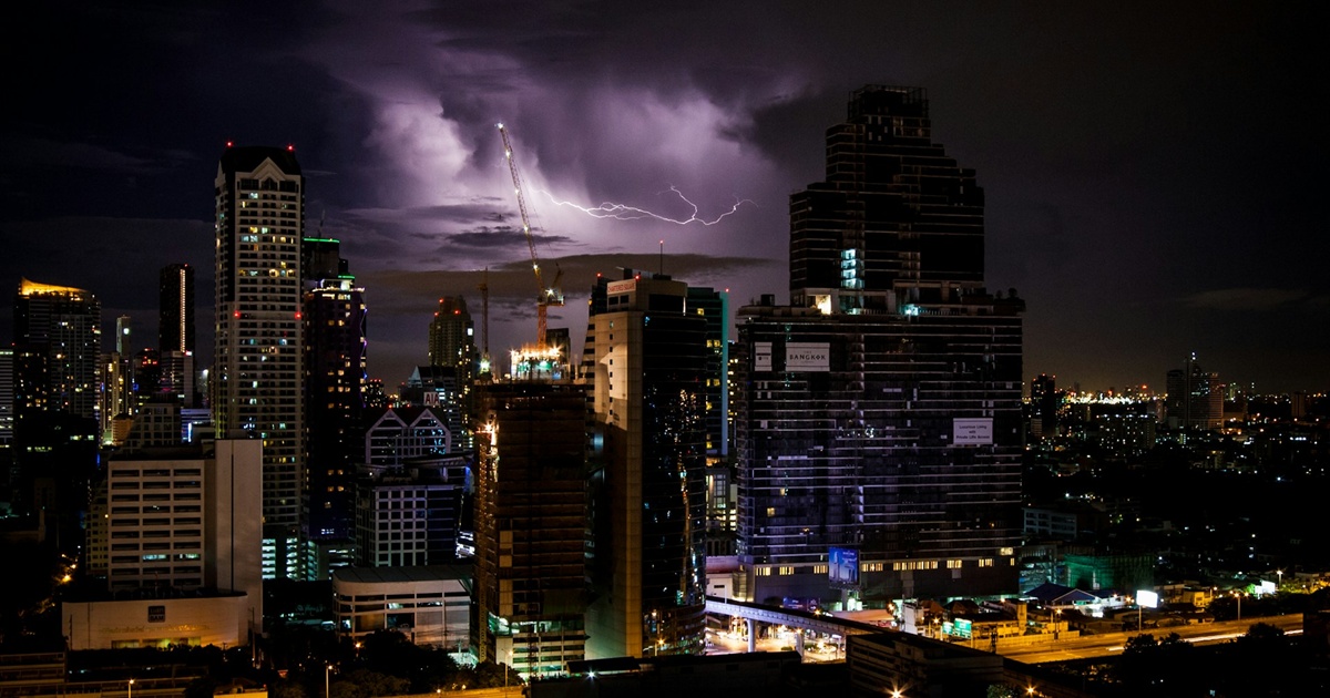 高層ビル群と雷が交差する都市の夜景