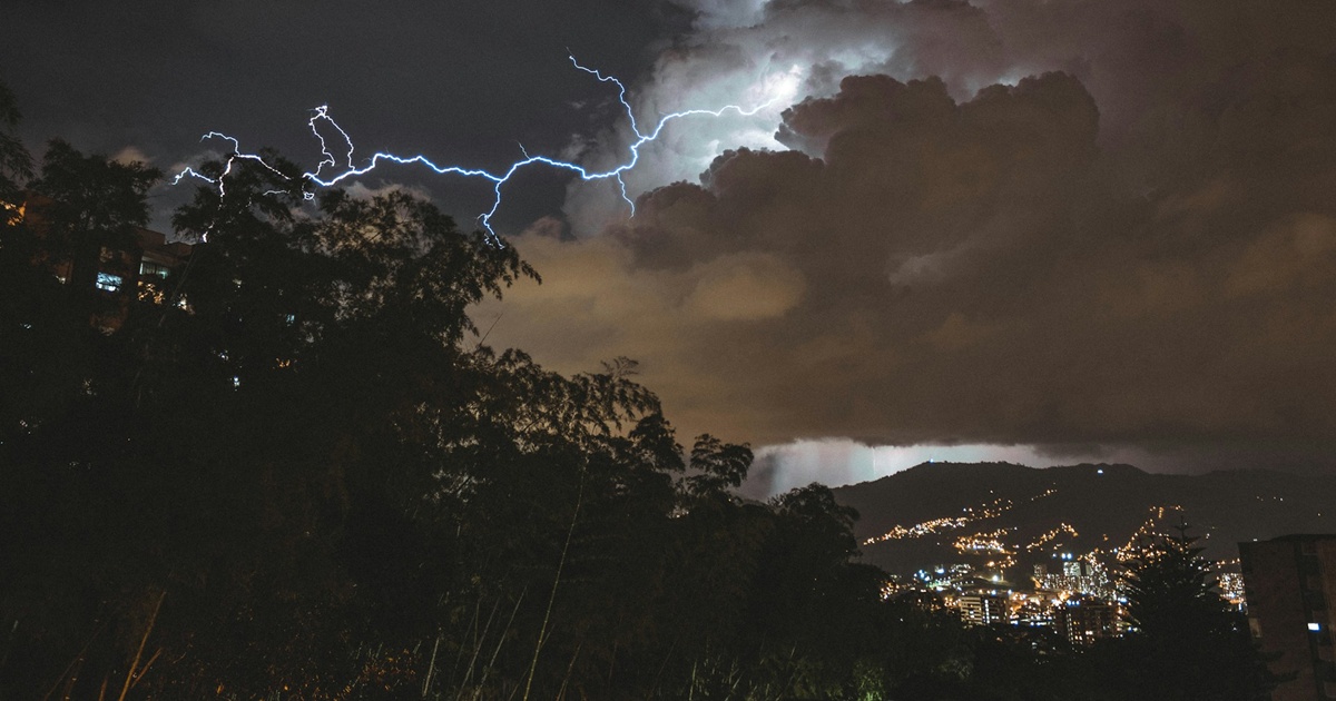 山間の都市に迫る雷と激しい雨雲