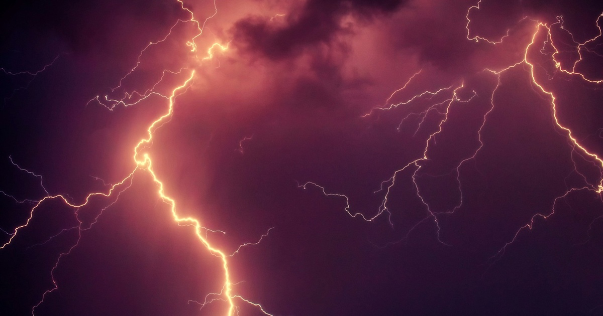 赤紫色の雲間に走る太い稲妻の光