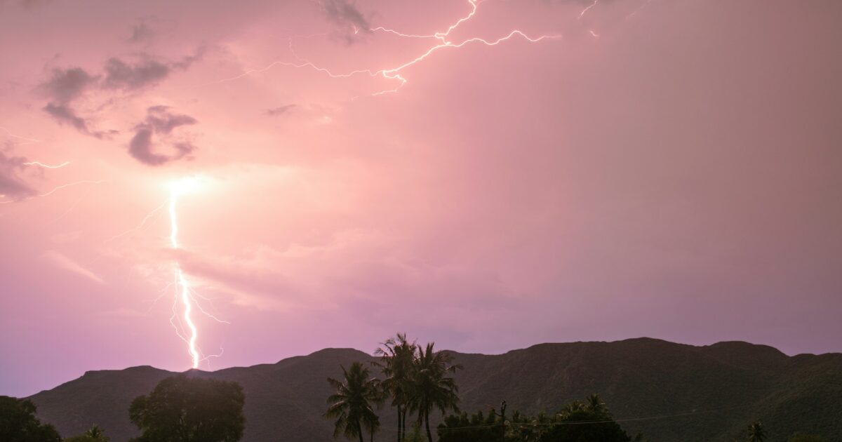 雷が山に落ちるピンク色の夕暮れ空